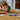 shows a child laying on the desk playing with the built lego car.