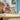 lego star wars 75362 ashoka tano's jedi shuttle 601 piece set. shows a child playing with the fully built jedi shuttle as the minifigures stand on the table.