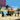 lego friends 42606 mobile bakery. shows a close up of the mobile bakery and a minifigure and dog standing waving goobye.
