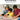 Shows a mother and 2 young boys helping each other put a jigsaw together.