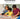 Shows a mother and 2 young boys helping each other put a jigsaw together.